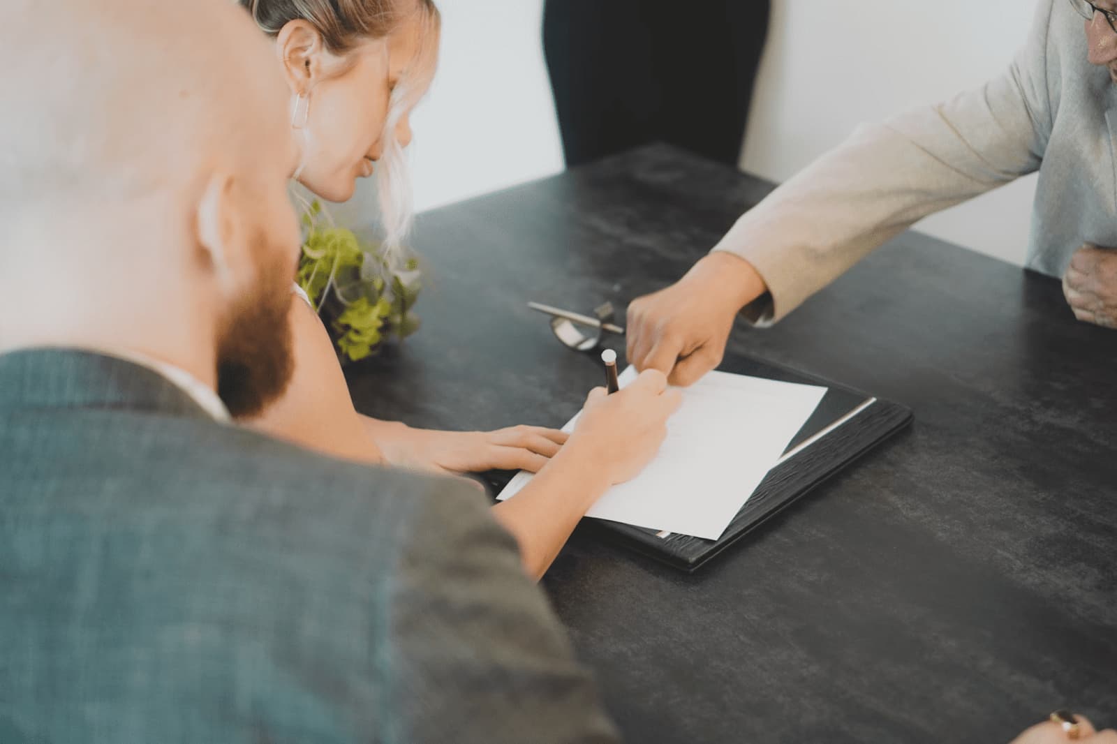 A man and women signing paperwork for their auto glass repair warranty