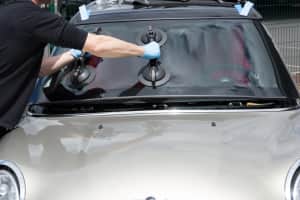 A person is installing a new windshield