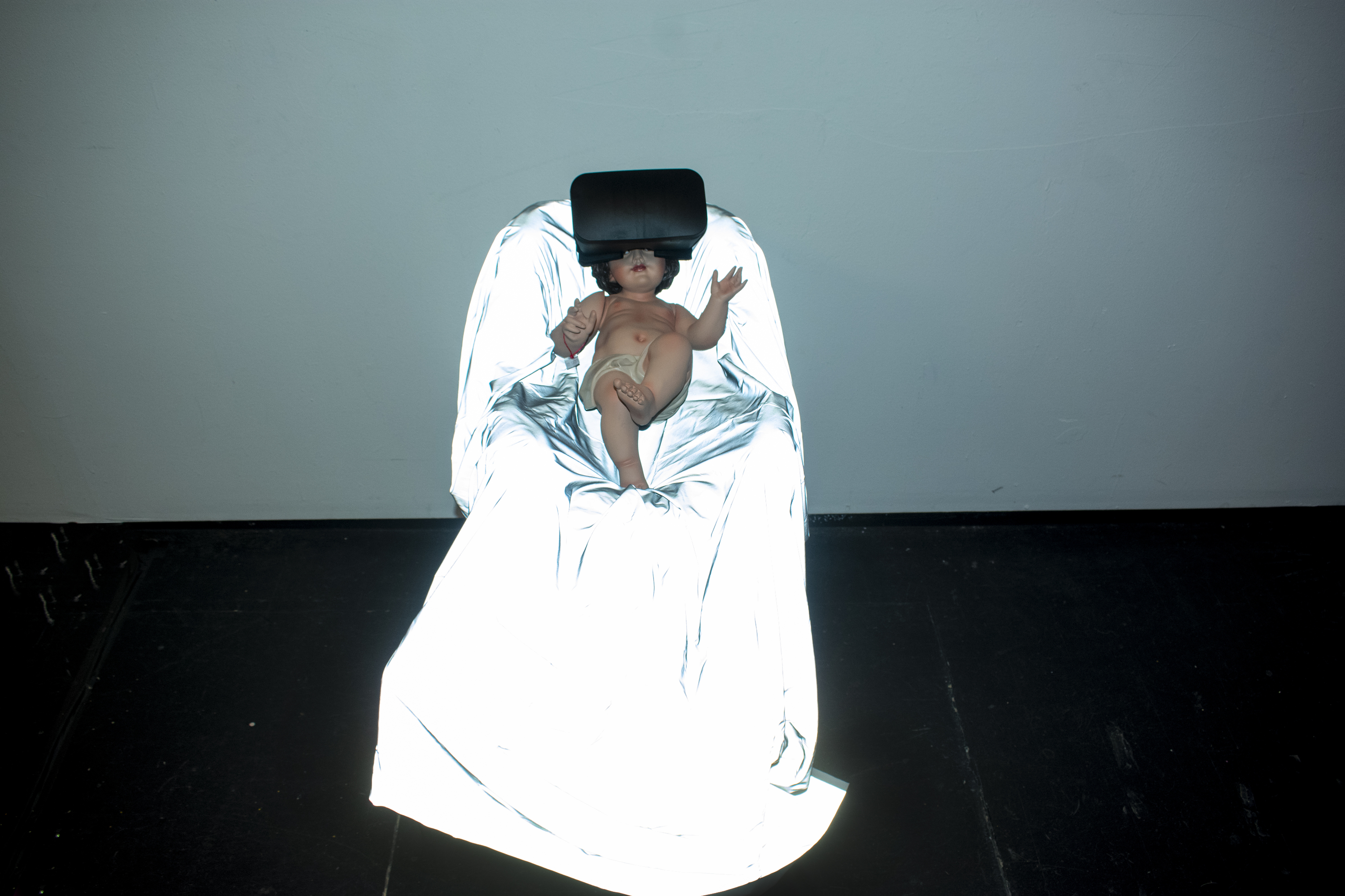Simulation Faith - Suspended baby Jesus sculpture with VR headset
