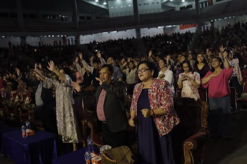 Jemaat mengangkat tangan dalam pujian
