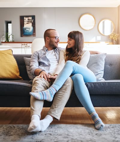 Happy couple sitting on couch in their new home