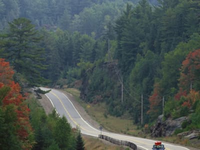 Winding road through autumn forest along rock face, Algonquin Provincial Park, Ontario