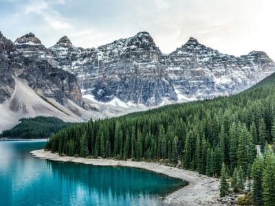 Moraine Lake with snow-dusted mountain peaks and pine forest shoreline, Banff National Park