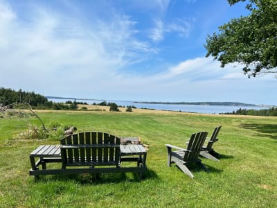 Adirondack chairs on green lawn overlooking the sea, Cape Breton Island, Nova Scotia