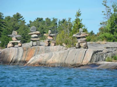 Inukshuk stone cairn on granite island shoreline, Thousand Islands, Ontario