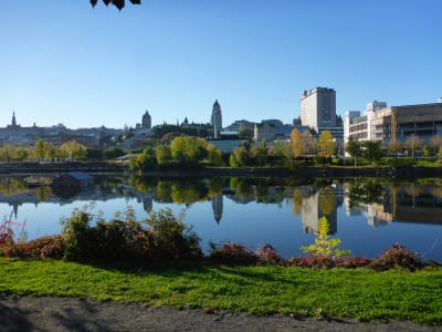 Panoramic view of Quebec City skyline reflected in the St. Lawrence River on a sunny autumn day