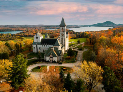 Aerial view of a small prairie town with a church surrounded by autumn foliage and lakes in Manitoba, Canada