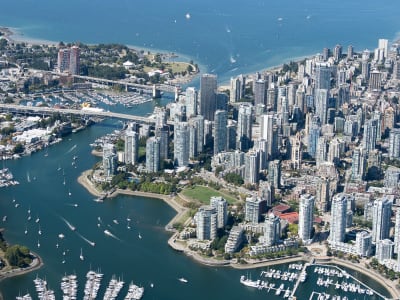 Aerial view of Vancouver's False Creek waterfront with sailboats, Granville Island and Stanley Park forest, BC