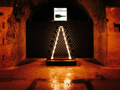 Candlelit champagne cellar with an arched stone vault and bottle rack in the Champagne region, France