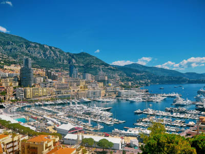 Aerial view of Monaco's Port Hercule with luxury yachts, high-rise buildings and the Mediterranean Sea