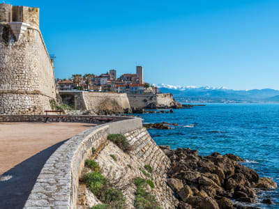 Antibes citadel and old town perched above the Mediterranean Sea with snow-capped Alps visible in the distance, France