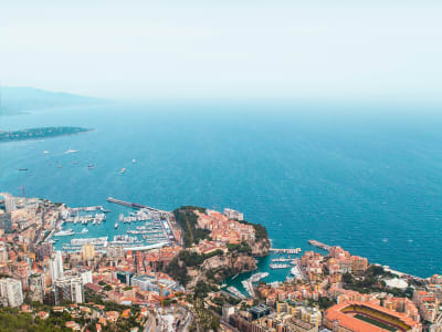 Aerial view of Monaco's coastline with the harbour, terracotta rooftops and turquoise Mediterranean Sea