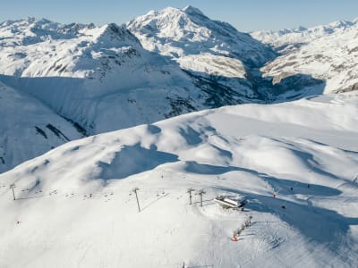 Wide open ski slopes with panoramic mountain views on a sunny day in Val d'Isère, French Alps