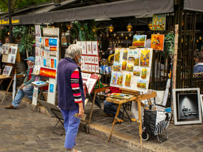 Artists selling paintings at the famous Place du Tertre outdoor art market in Montmartre, Paris France