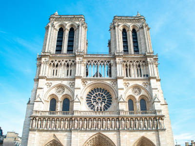 Full frontal view of Notre-Dame Cathedral's Gothic facade with visitors at the ent