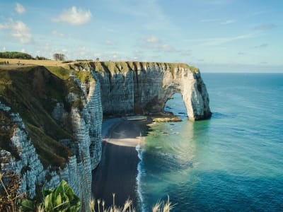 Close-up of the natural chalk arch and cliff path at Étretat with turquoise sea below, Normandy France