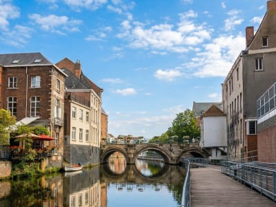 Historic buildings and stone bridge along the Dijle river in the city centre of Mechelen, Belgium