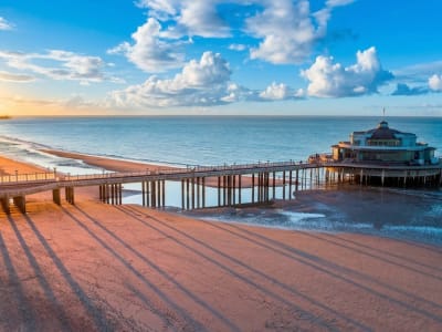 Wooden beach pier extending over the North Sea at sunset on the Belgian coast