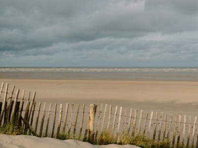 Wide empty North Sea beach with dramatic low clouds and gentle waves at Noordwijk, Netherlands