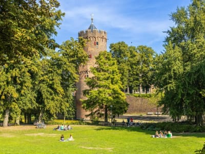 Medieval round tower of Buren castle surrounded by lush green trees in Gelderland, Netherlands