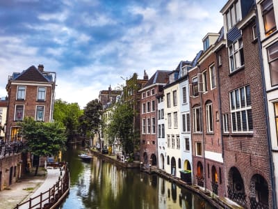 Narrow Oudegracht canal with tall historic brick canal houses and wharves in Utrecht city centre, Netherlands
