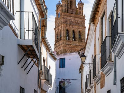 Narrow white-washed street with a Moorish-style church tower in the Albaicín quarter of Granada, Spain