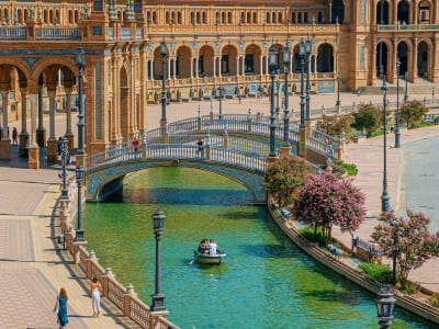 Plaza de España Seville canal bridge with colorful azulejo tilework and tourists