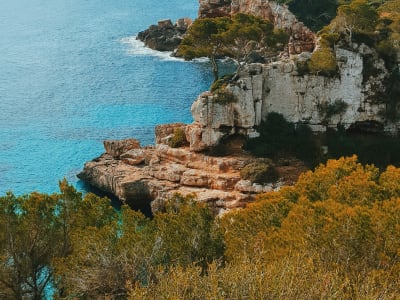 Rocky golden cliffs meeting turquoise sea at secluded beach in Mallorca Spain