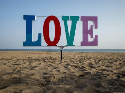 Colorful LOVE sign on Maspalomas beach Gran Canaria with grey sky and Atlantic ocean