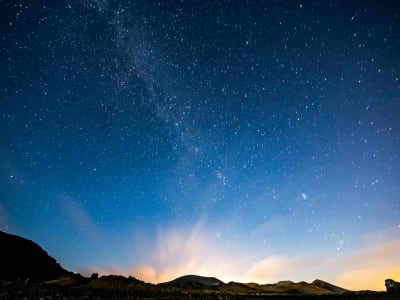 Milky Way over Timanfaya volcanic mountains Lanzarote with glowing horizon at night Canary Islands