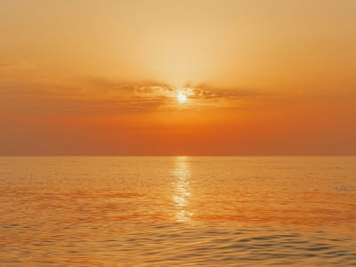 Golden sunset over Mediterranean sea on Costa del Sol with orange sky reflecting on water Spain