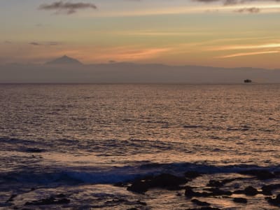 Golden sunset over calm Mediterranean sea with distant mountain silhouette Costa Dorada Spain