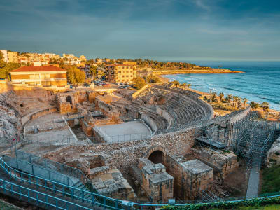 Aerial view of Tarragona Roman amphitheatre ruins with city and Mediterranean coastline Spain