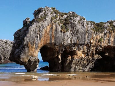Natural rock arch on Playa de Gulpiyuri beach with sandy cove Cantabria northern Spain