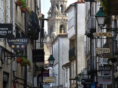 Lively narrow street in Santiago de Compostela old town with restaurant signs and lanterns Galicia Spain