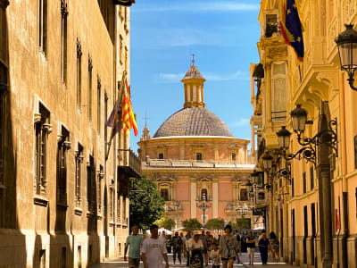 Valencia Cathedral dome and Baroque church facade with Valencian flag in old town Spain