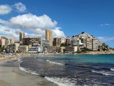 Benidorm Poniente beach with turquoise sea resort hotels and rocky headland Costa Blanca Spain