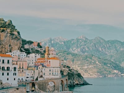 Amalfi Cathedral and town panorama with white and terracotta buildings on dramatic cliff Italy