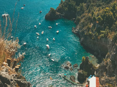 Aerial view of Amalfi cove with turquoise water boats and steep cliffs Campania Italy
