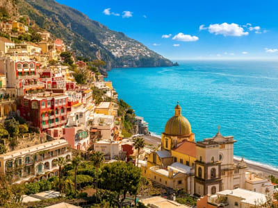 Positano pastel village with Santa Maria Assunta dome and colorful buildings above turquoise bay Italy