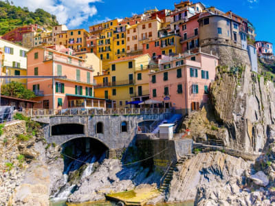 Manarola Cinque Terre close-up of colorful stacked houses with arched boat storage and rocky coast Italy