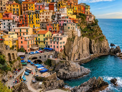 Manarola Cinque Terre with pastel painted houses steep rock face and small harbour Italy