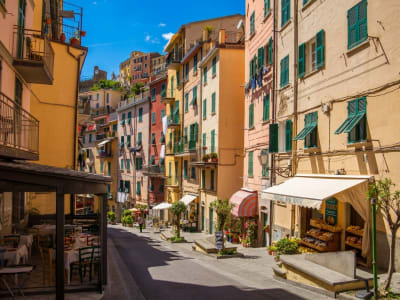 Narrow lane in Riomaggiore Cinque Terre with pastel buildings laundry and arched passages Italy