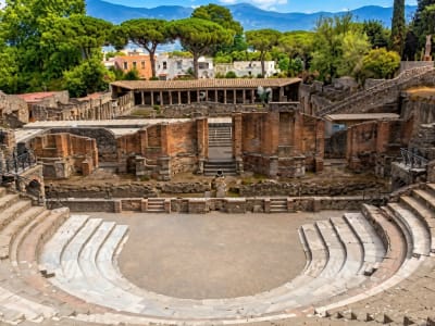 Ancient Greek theatre of Taormina or Pompeii with stone seating and mountain backdrop Italy
