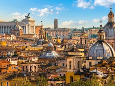 Panoramic view over Rome's historic rooftops with domes and church spires at golden hour