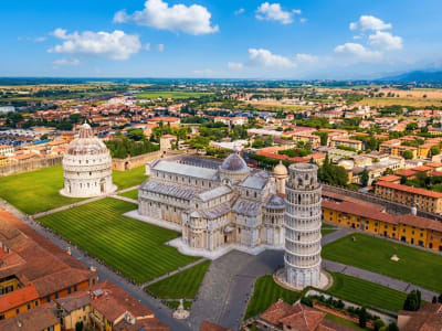 Aerial view of the Piazza dei Miracoli with the Leaning Tower, cathedral and baptistery on a green lawn in Pisa