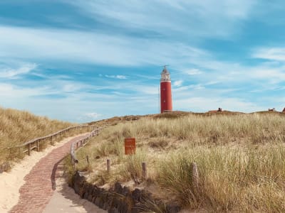 Red and white striped lighthouse in the dunes of Texel island, Wadden Islands, Netherlands