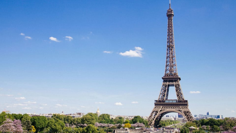 Eiffel Tower rising above the green parks of Paris on a sunny spring day, France