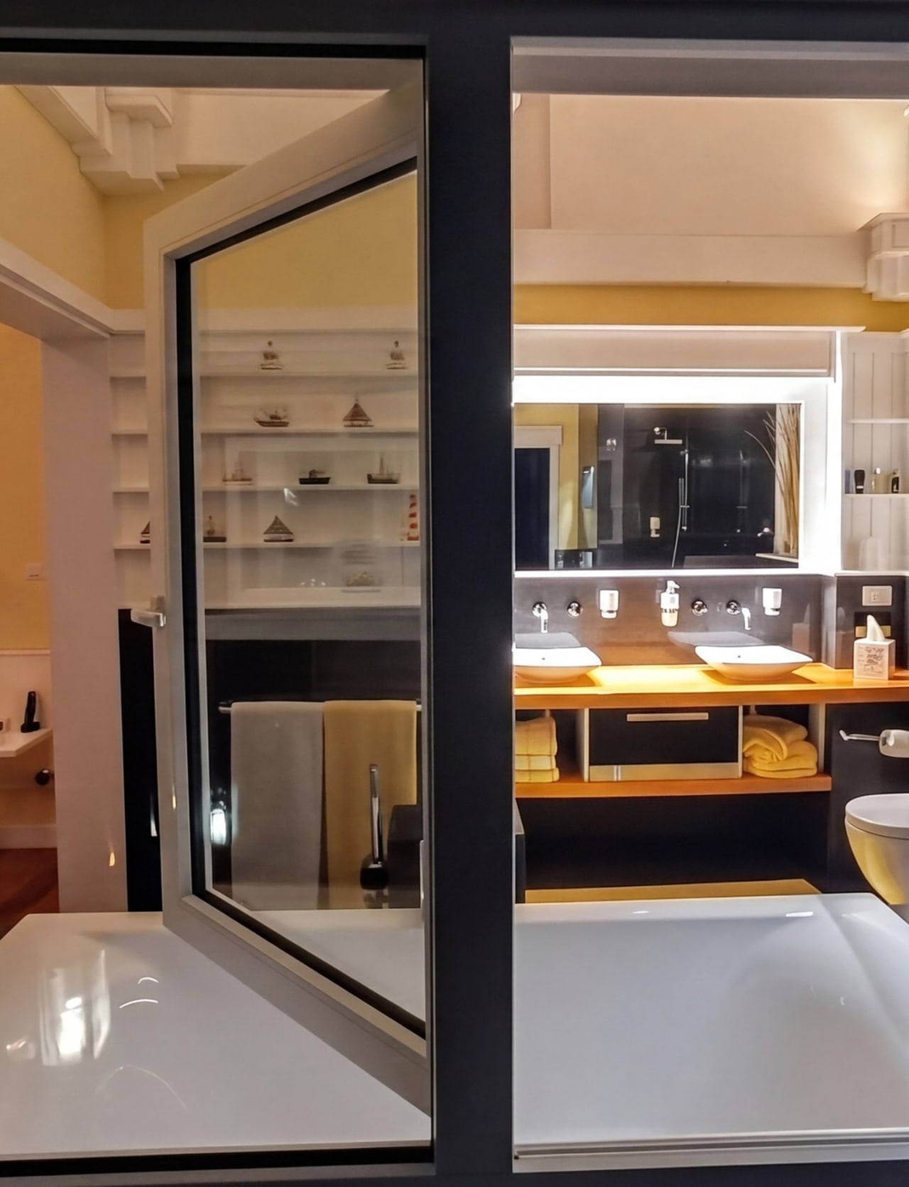 Bay House Seaview suite at night — looking through Koemmerling tilt-and-turn frame into warm-lit bedroom and ensuite