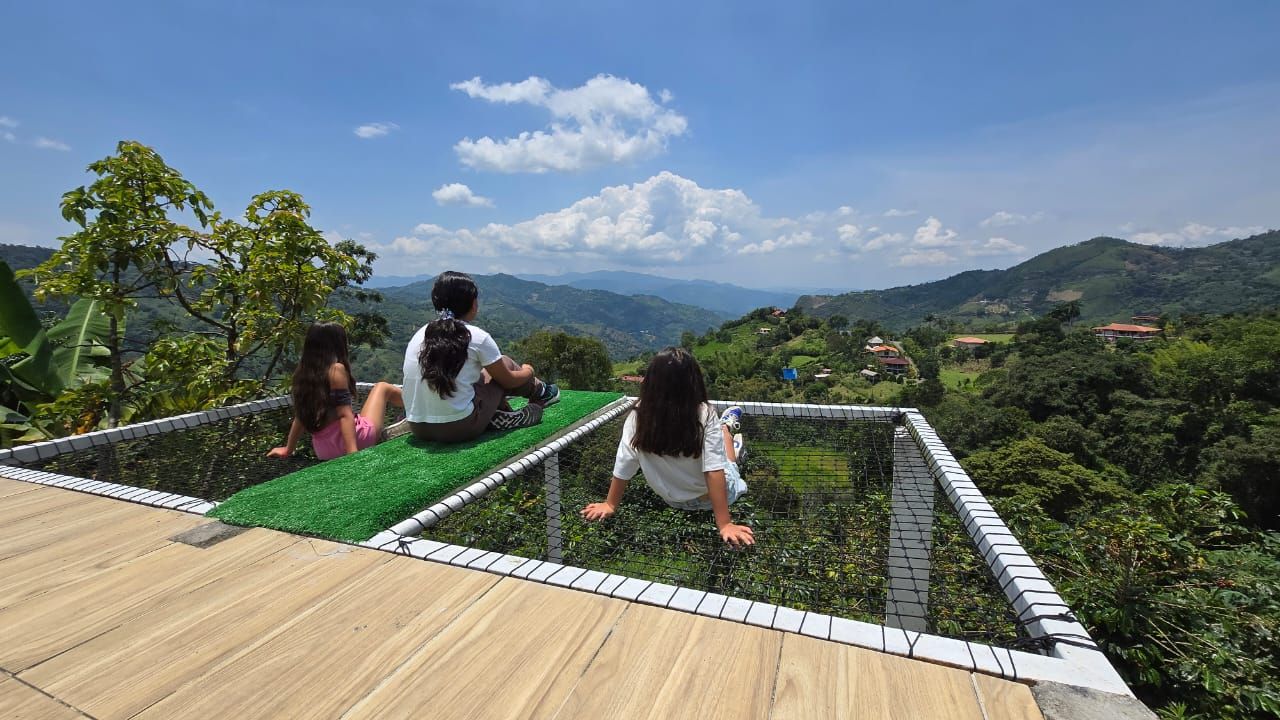 Niñas sentadas en malla con vista a la montaña